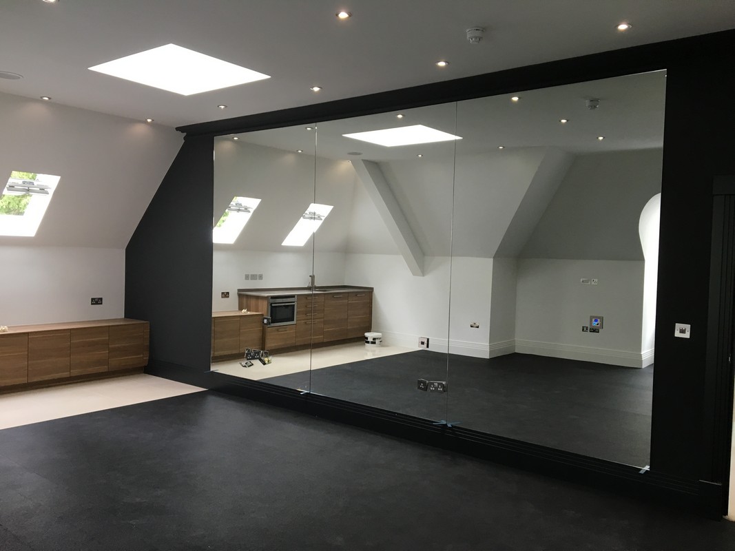Frameless glass wall dividing loft conversion in Earlsfield