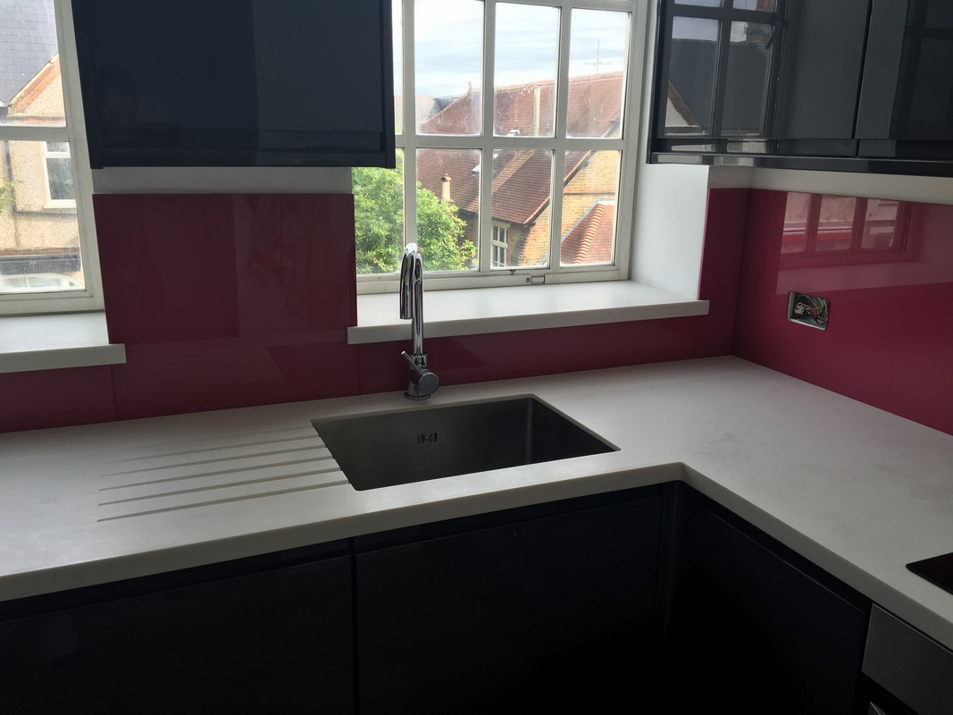 Deep plum coloured glass splashback in modern Earlsfield kitchen